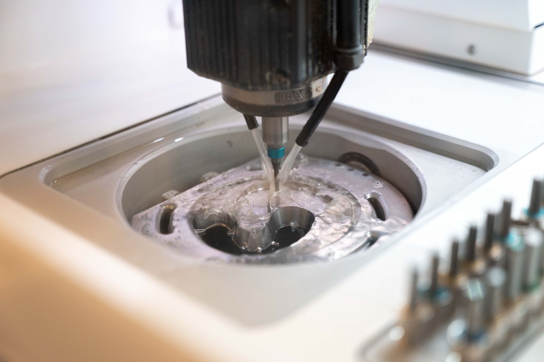 Fräswerkzeug bearbeitet einen Rohling in der CAD/CAM-Fräsmaschine des Dentallabors in Norderstedt