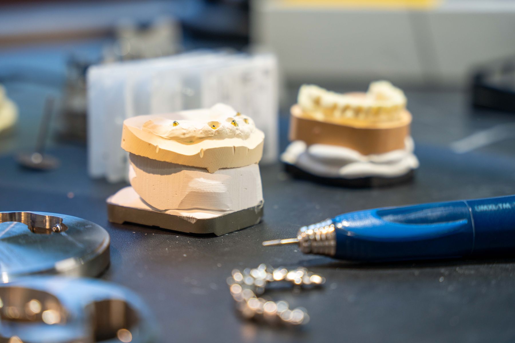 Kiefermodell mit Mikromotor und Fräsern auf dem Arbeitstisch im Dentallabor Norderstedt