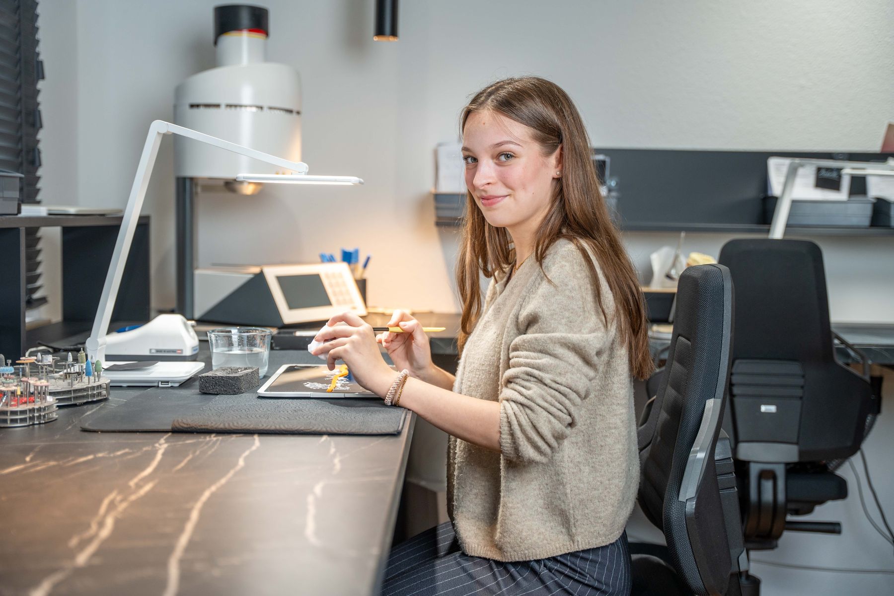 Zahntechnikerin am Arbeitsplatz mit Modell und Mikromotor im Dentallabor Norderstedt